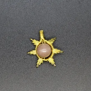 Detailed view of handmade sunburst pendant featuring gold wire wrapping and sunstone stone