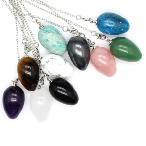 Detailed macro view of various natural stone egg pendulums on delicate silver chains.