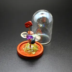 Detail of a mini crystal tree of life with natural stones and a glass dome cover.