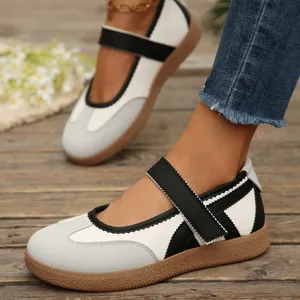 Primo piano di eleganti sneakers Mary Jane con cinturino a strappo e color-block.
