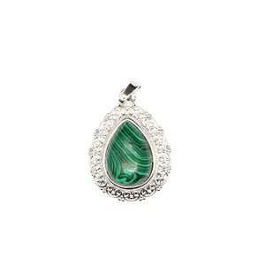Detailed macro view of teardrop malachite pendant with ornate silver filigree border.