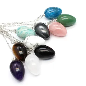 Macro detail of egg-shaped natural stone crystal pendulum necklaces in assorted colors