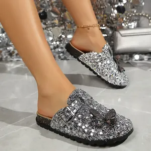 Close-up of silver sequined clog slippers with butterfly and buckle detail