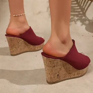 Detail of red suede peep-toe wedge sandals with cork-textured platform heel.
