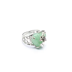 Detailed view of an adjustable silver ring featuring a green heart stone and flowers.