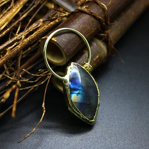 Close-up of marquise-cut labradorite pendant with blue fire flash and gold ring bail