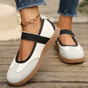 Primo piano di sneakers Mary Jane con cinturino in velcro e suola in gomma su legno