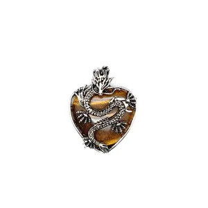 Dettaglio del drago d'argento su un ciondolo a cuore in occhio di tigre vintage
