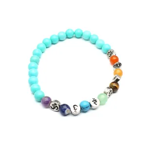 Detailansicht eines 7-Chakra-Armbands mit 6 mm Natursteinperlen und Om-Zwischenstücken.