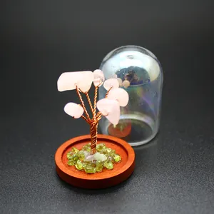 Macro view of a miniature rose quartz crystal tree of life with copper wire and glass dome