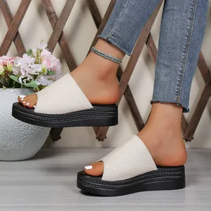 Side view of white ribbed platform slide sandals for women in a casual summer setting