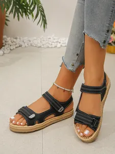 Dettaglio di sandali platform neri con velcro e suola in iuta intrecciata sul piede