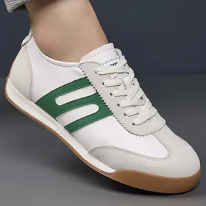 Close-up of men's white and green retro sneakers featuring a classic gum sole design
