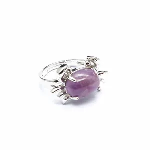 Detailansicht eines verzierten krabbenförmigen Rings mit poliertem lila Stein-Inlay