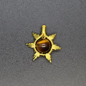 Close-up of handmade gold wire-wrapped sun pendant with brown tiger eye gemstone