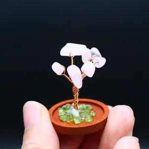 Close-up of miniature rose quartz life tree with copper wire and wooden base
