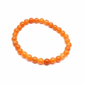 Detailed macro view of 6mm orange natural stone round beads on a minimalist beaded bracelet