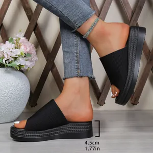 Black platform slide sandals with ribbed fabric upper and 4.5cm wedge heel detail.