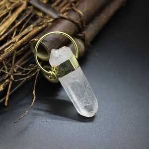 Macro shot of a raw clear crystal point pendant with a stylish gold-tone metal cap