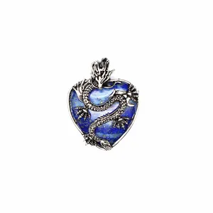 Dettaglio ravvicinato di un drago vintage avvolto attorno a un ciondolo a cuore blu