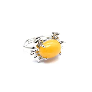 Detaillierte Makroansicht eines kreativen krabbenförmigen Rings mit gelbem Stein.