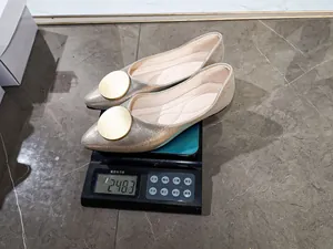 Vista de detalle de zapatos planos dorados en una báscula con un peso ligero de 248,3g