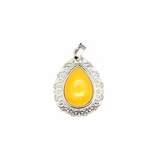 Macro detail of teardrop natural stone pendant with intricate silver lace border