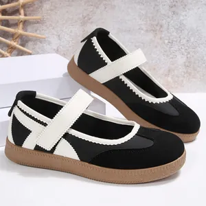 Scarpe basse Mary Jane moderne bianche e nere con cinturino in velcro e suola in gomma.