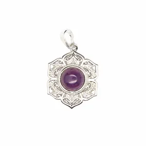 Gros plan d'un pendentif mandala en argent orné d'un cabochon en cristal violet.