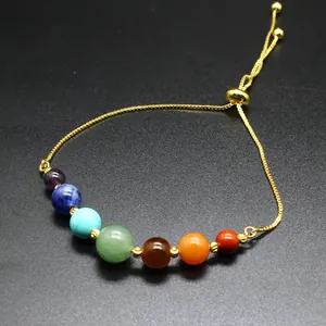 Macro view of 7 chakra natural stone beads on a gold adjustable bracelet