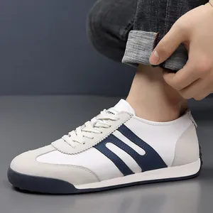 Close-up of men's casual white sneakers with navy stripes and suede details.