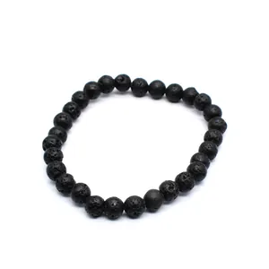 Detailed macro view of the natural black lava stone beads on an elastic bracelet