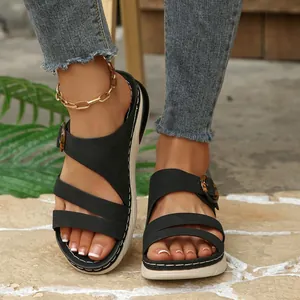 Close-up view of stylish black wedge platform sandals for women on paved ground