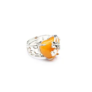 Detail view of adjustable silver ring with orange heart-shaped natural stone and flowers