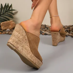 Close-up of stylish brown suede wedge sandals with cork texture platform base