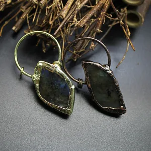 Detailed close-up of natural raw Labradorite pendants featuring gold and copper finishes.