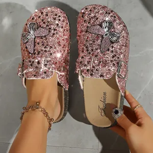 Close-up detail of pink sequin butterfly clogs with stylish buckle and thick sole