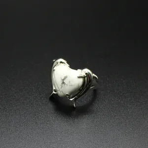 Vista dettagliata di un anello d'argento con cuore in marmo bianco e doppio delfino