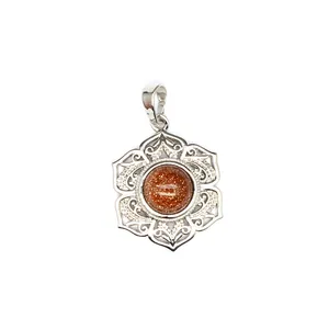 Détail macro d'un pendentif fleur argenté avec une perle centrale en pierre d'or