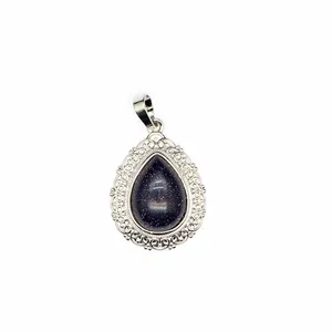 Detailed macro view of teardrop pendant with blue goldstone and filigree frame