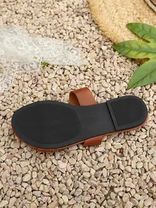 Close-up detail of the black non-slip sole of women's brown casual beach sandals.