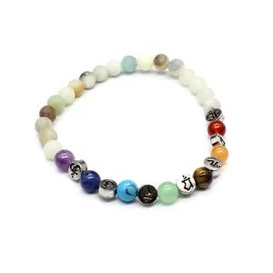 Detaillierte Makroansicht eines 6-mm-Naturstein-Chakra-Armbands mit gravierten Om-Symbolen.