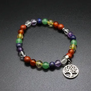 Detail view of a multi-colored chakra stone bracelet with a silver tree of life charm.