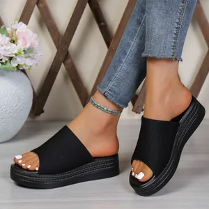 Close-up detail of women's stylish black platform slides with a comfortable ribbed fabric strap