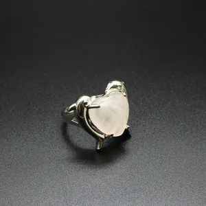 Primo piano macro di un anello a delfino in argento con quarzo rosa a forma di cuore