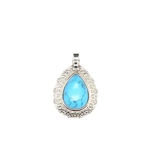 Vintage teardrop turquoise pendant with ornate silver filigree lace detail on white