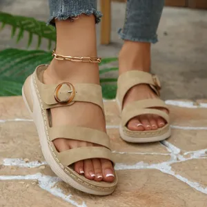 Close-up of women's khaki wedge sandals with thick soles on outdoor stone ground