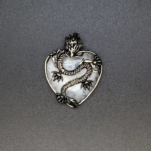 Dettaglio ravvicinato di ciondolo a cuore in cristallo retrò con design a drago intrecciato