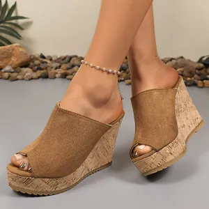 Close-up detail of women suede peep-toe wedge sandals featuring cork pattern platform