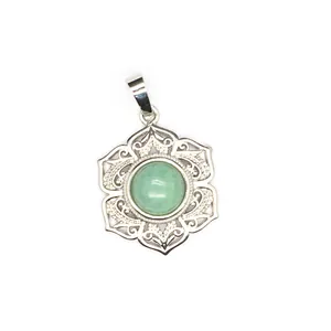 Gros plan d'un pendentif en dentelle florale en argent avec un cristal vert au centre.